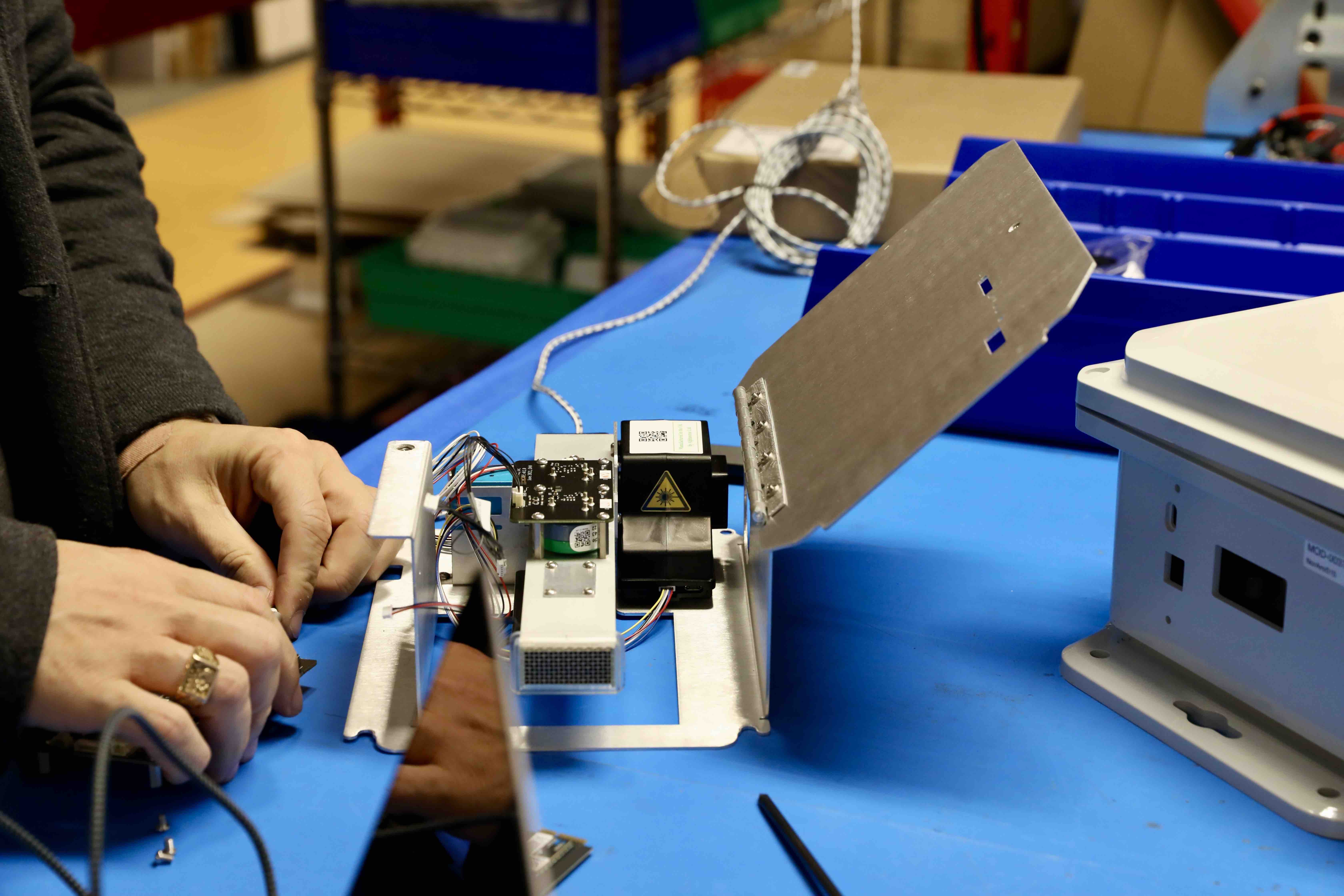 an open device with a person's hands working on it